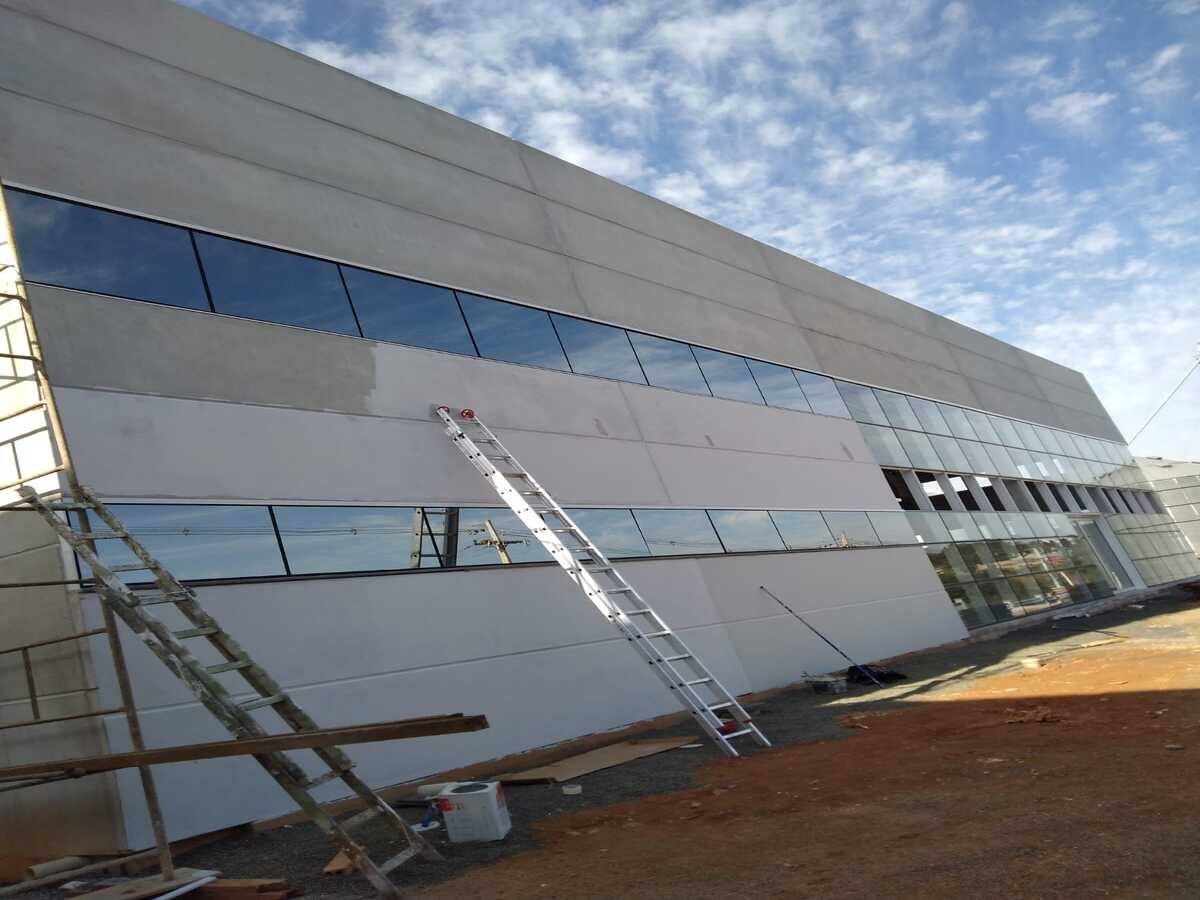 Pintura externa sendo realizada na fachada de um barracão comercial